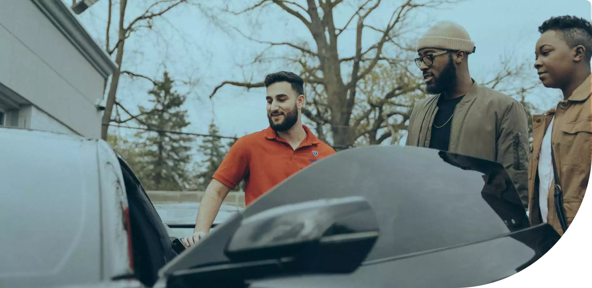 Car dealer showing a couple the interior of a car on his lot