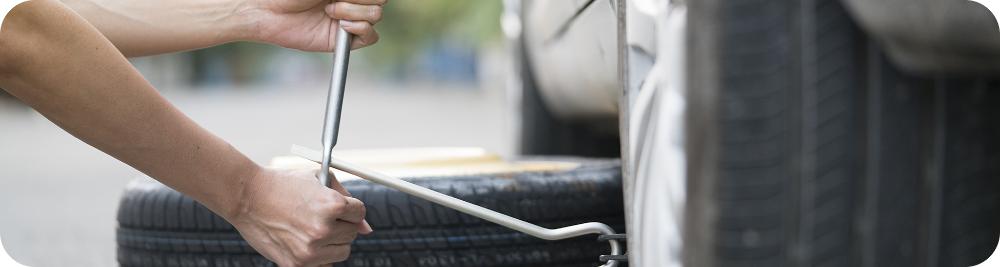 close up woman changing flat tire