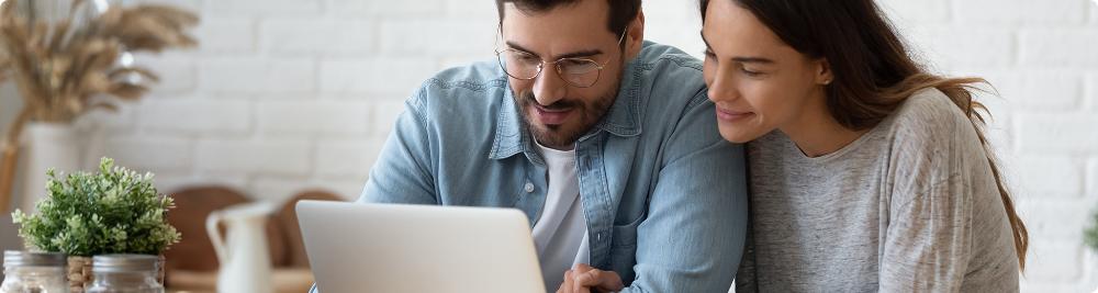 couple look at computer screen and smile