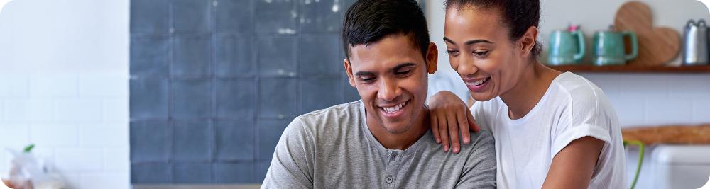 couple looks at computer smiling