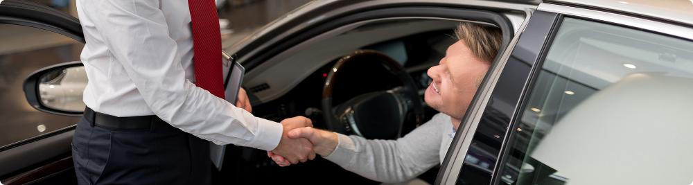 customer shakes car dealer hand