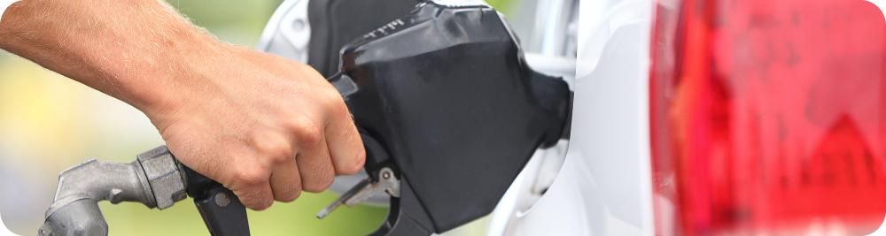 hand holding gas pump handle into car