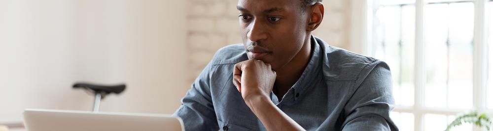 young man concentrates at computer screen