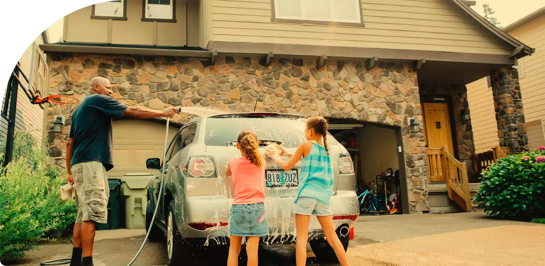 Two happy young girls in backseat of car, looking out window